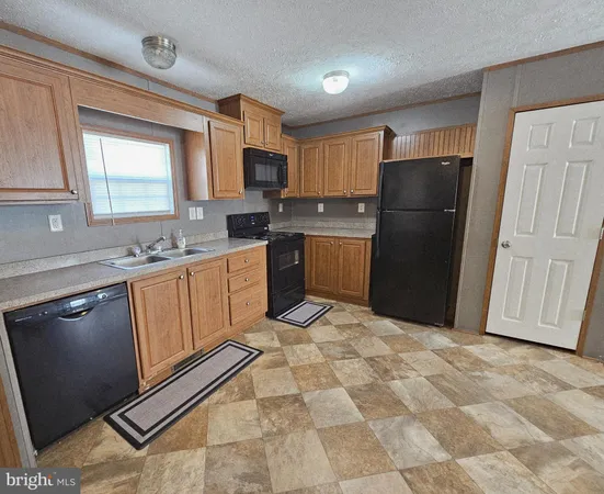 a kitchen with a refrigerator sink and cabinets