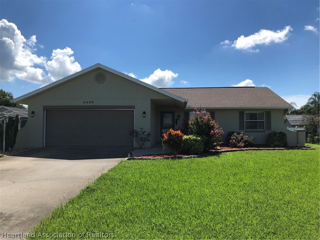 4440 Mandarin Road Sebring, FL 33875 - Photo 1 of 17 a front view of a house with a yard and garage