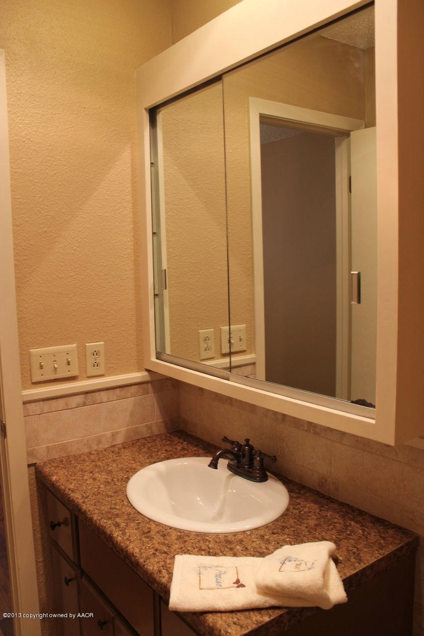 5130 McCarty Boulevard Amarillo, TX 79110 - Photo 11 of 26 a bathroom with a granite countertop sink and a mirror