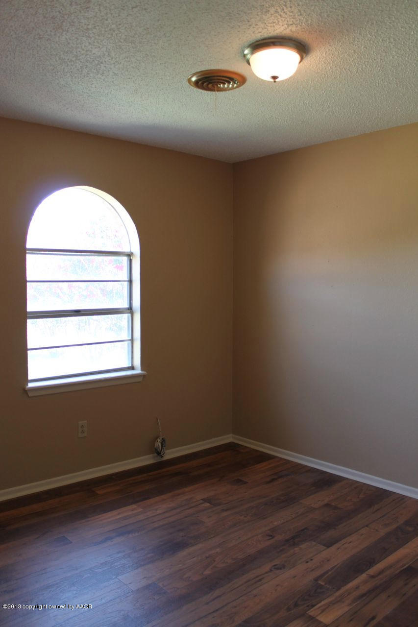 5130 McCarty Boulevard Amarillo, TX 79110 - Photo 14 of 26 an empty room with wooden floor and windows