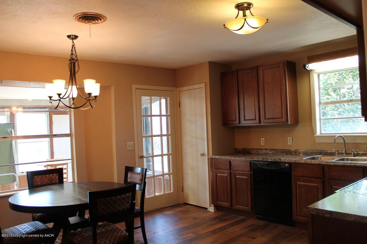 5130 McCarty Boulevard Amarillo, TX 79110 - Photo 6 of 26 a kitchen with a chandelier sink dining table and chairs