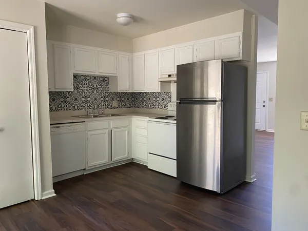 a kitchen with a refrigerator sink and cabinets