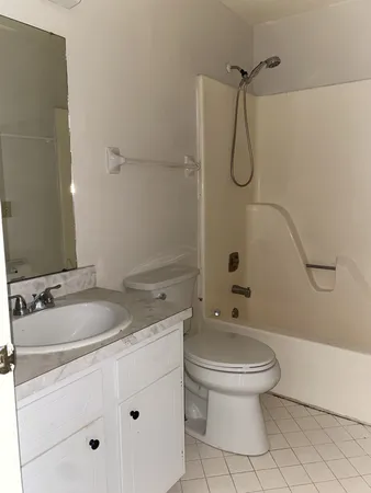 a bathroom with a granite countertop sink a toilet and shower