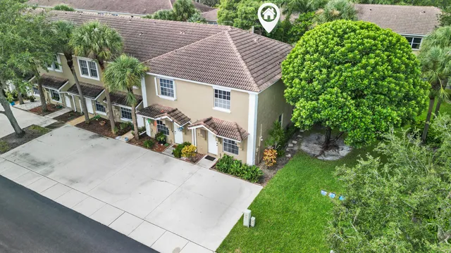a view of a house with a yard and potted plants