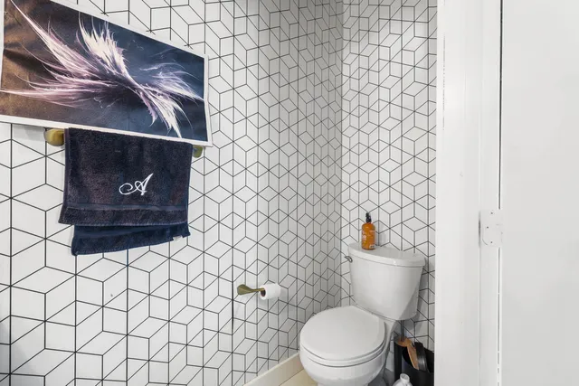 a white toilet sitting next to a white wall