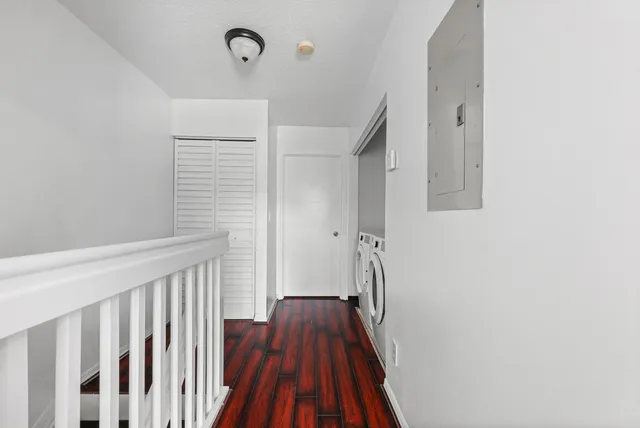a view of a hallway with wooden floor and staircase