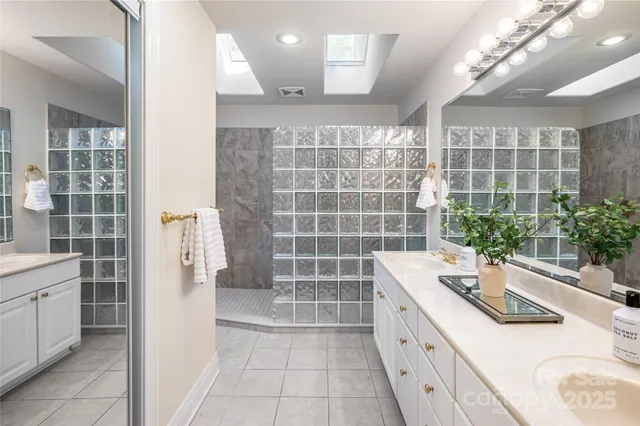 a bathroom with a double vanity sink a large mirror and a shower