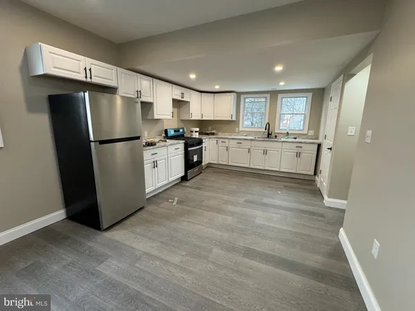 a kitchen with a refrigerator a sink and a stove top oven