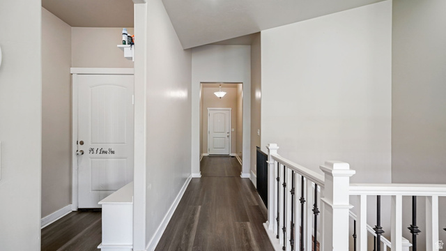 6062 Spring Street Stansbury Park, UT 84074 - Photo 18 of 36 Entryway featuring wood-finish flooring, light neutral wall tones, white trim, and a white staircase with black wrought iron balusters