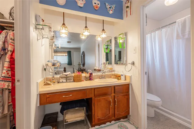 a bathroom with a sink vanity mirror and toilet