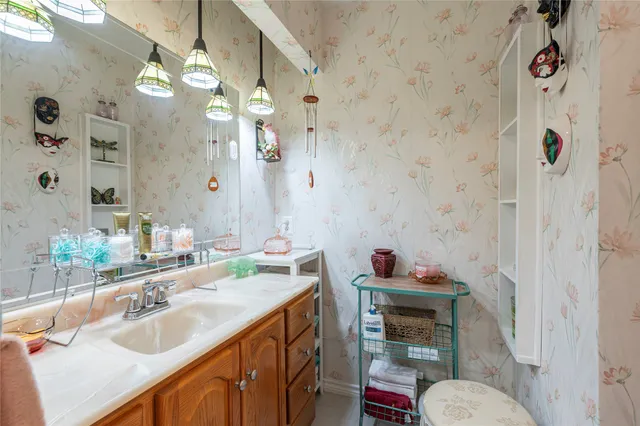 a bathroom with a sink vanity mirror and toilet