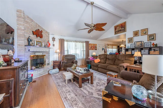 a living room with furniture a fireplace and a ceiling fan