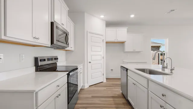 a kitchen with cabinets stainless steel appliances a sink and a refrigerator