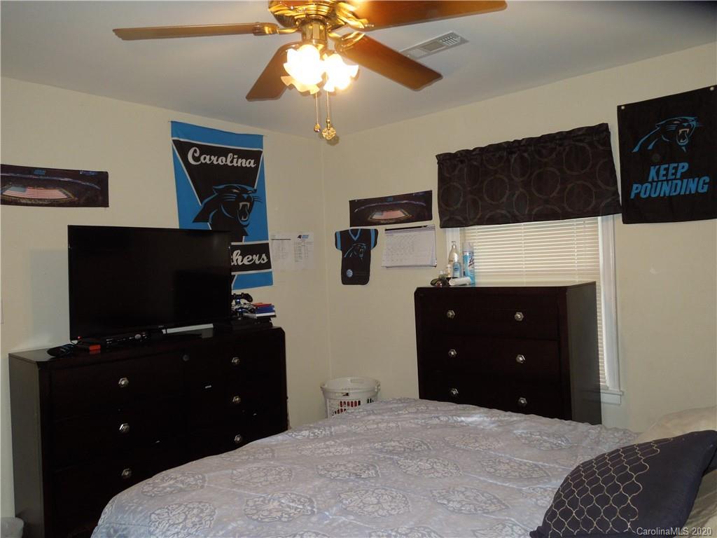 5531 Hickory Grove Road Charlotte, NC 28215 - Photo 19 of 24 a bedroom with a bed and a flat tv screen on dresser