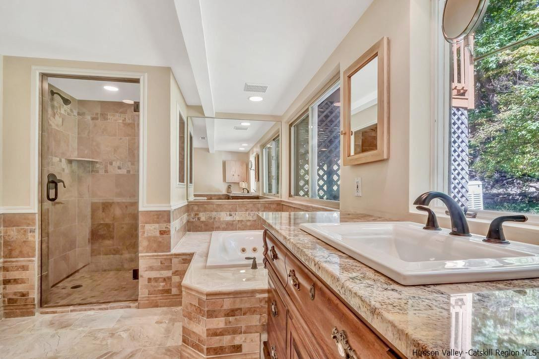 71 Carly Road Woodstock, NY 12498 - Photo 16 of 34 a bathroom with a granite countertop sink a mirror and shower