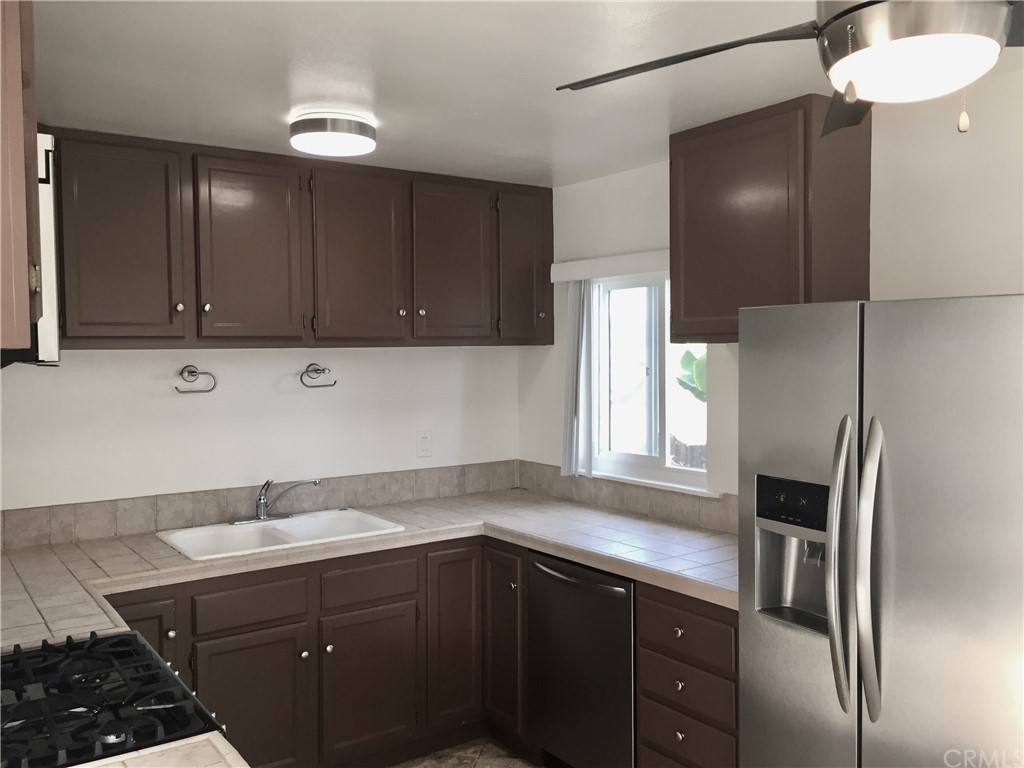 970 Linden Place Costa Mesa, CA 92627 - Photo 3 of 9 a kitchen with a sink stainless steel appliances and cabinets
