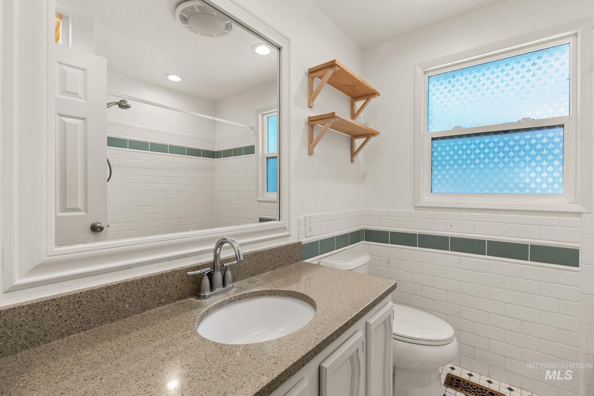 928 3rd Street Clarkston, WA 99403 - Photo 21 of 44 Bathroom featuring a vanity with an integrated sink, a speckled countertop, and white cabinetry