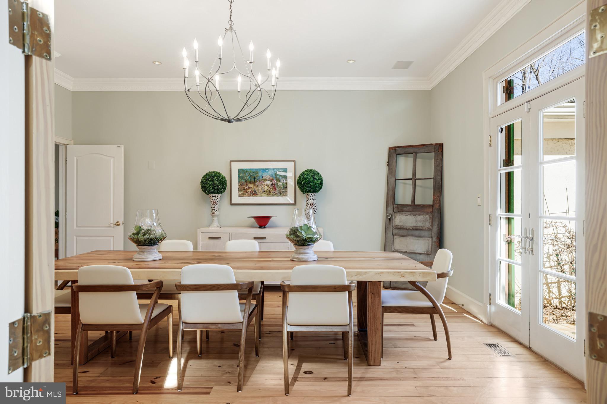 1127 Bellview Road McLean, VA 22102 - Photo 9 of 67 a dining room with wooden floor a chandelier a wooden table and chairs