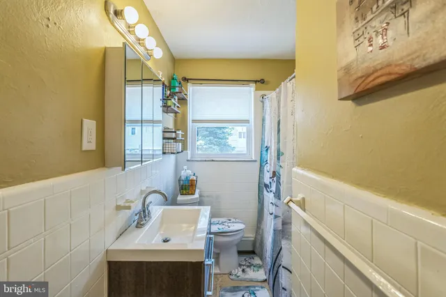 a bathroom with a sink a toilet and a window
