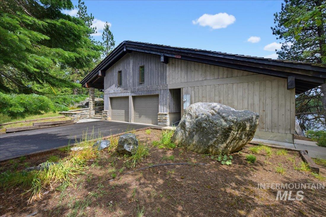 3800 Warren Wagon Road McCall, ID 83638 - Photo 28 of 50 Two-car garage with wood-paneled siding and a stone foundation