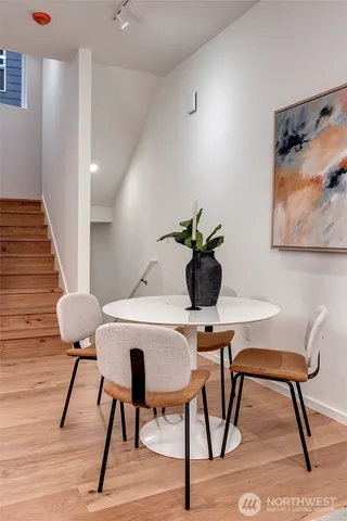 a kitchen with stainless steel appliances kitchen island granite countertop a table chairs and a refrigerator