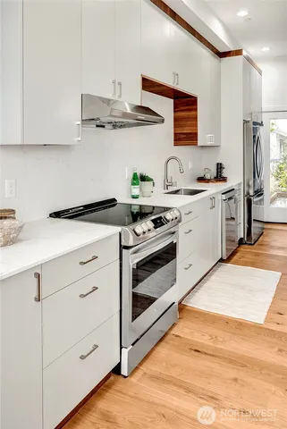 a kitchen with stainless steel appliances granite countertop a sink and a stove