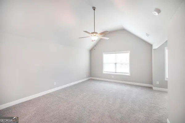 en empty room with window and a ceiling fan
