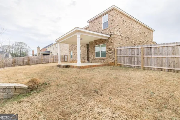 a view of a house with a wooden fence
