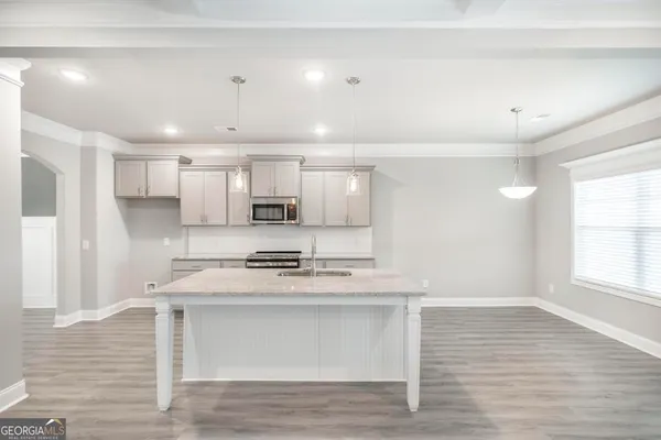 a kitchen with stainless steel appliances granite countertop a stove a sink and white cabinets
