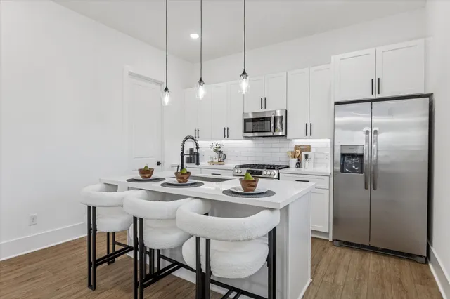 a kitchen with a dining table chairs refrigerator and microwave