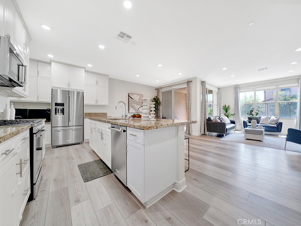 a kitchen with white cabinets and stainless steel appliances