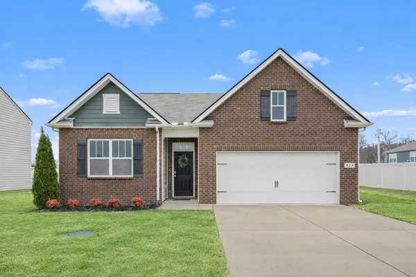 a front view of a house with a yard and garage