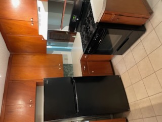 7402 Southgate Lane, Unit B Austin, TX 78744 - Photo 6 of 16 a kitchen with granite countertop a stove and a refrigerator