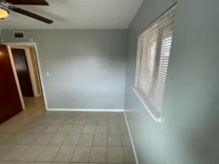 an empty room with closet and a chandelier fan