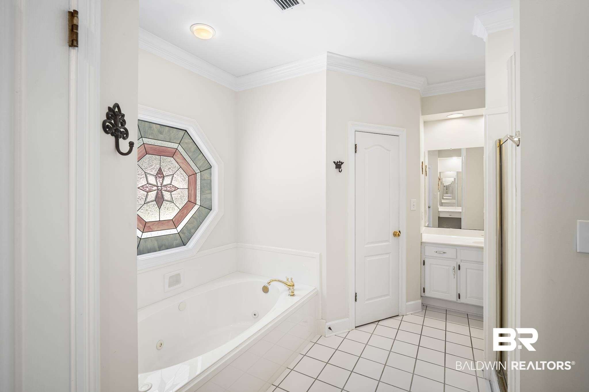 402 Potters Mills Road Daphne, AL 36526 - Photo 25 of 45 Bathroom with a whirlpool tub, tile patterned floors, vanity, crown molding, and baseboards