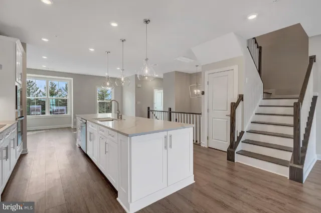 an open kitchen with a sink and wooden floor