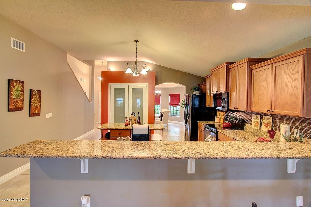 1202 Becket Place Melbourne, FL 32940 - Photo 11 of 38 a view of a kitchen with granite countertop a sink and a dining table