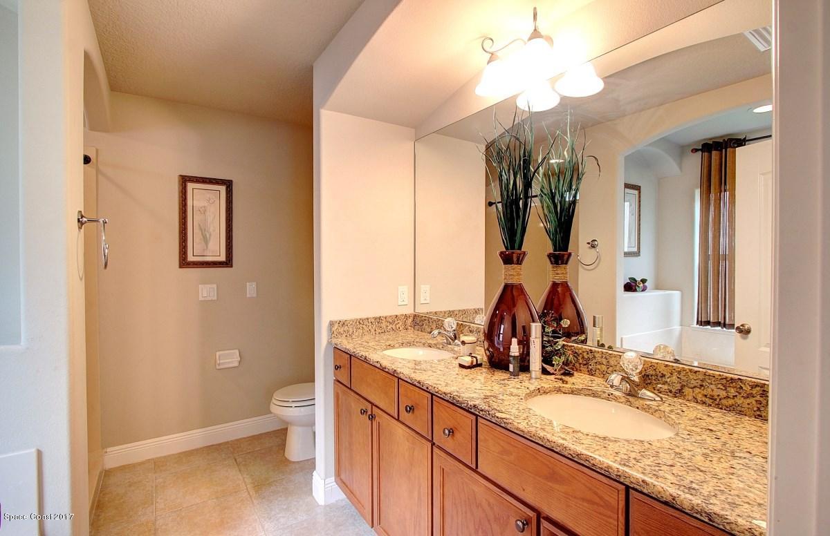 1202 Becket Place Melbourne, FL 32940 - Photo 17 of 38 a bathroom with a granite countertop sink and a mirror