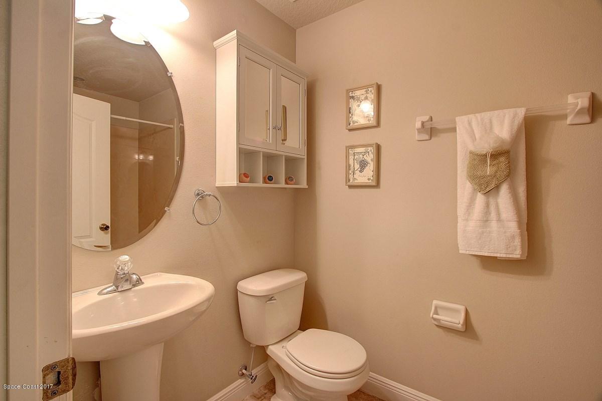 1202 Becket Place Melbourne, FL 32940 - Photo 21 of 38 a bathroom with a toilet a sink and mirror