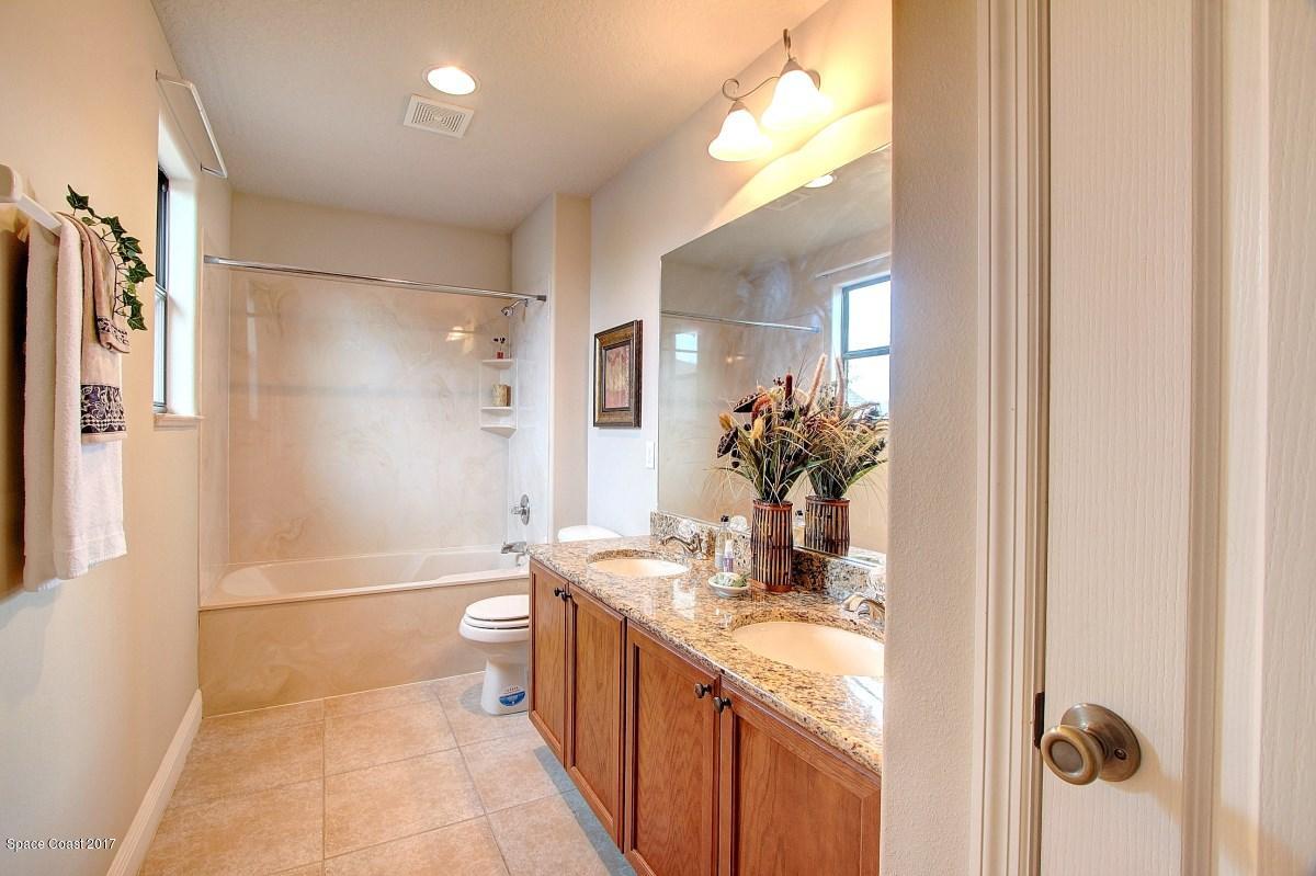 1202 Becket Place Melbourne, FL 32940 - Photo 24 of 38 a bathroom with a granite countertop sink a toilet and shower