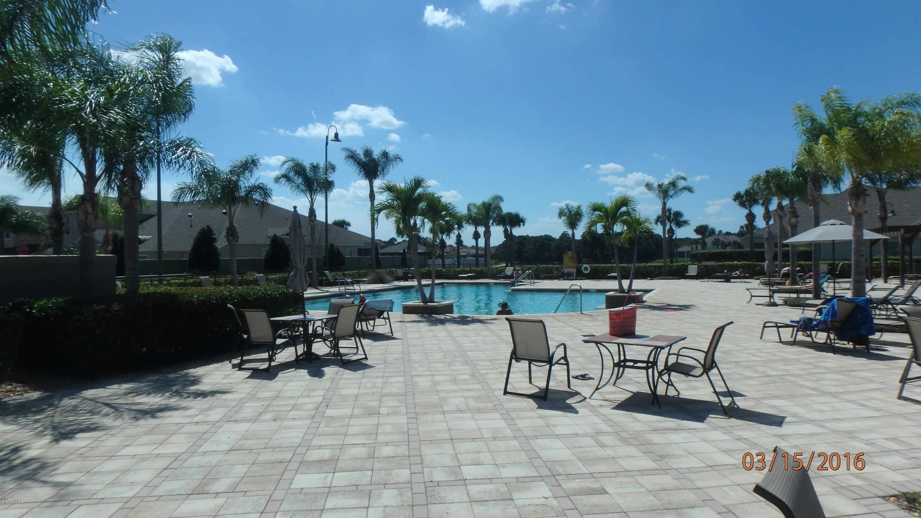 1202 Becket Place Melbourne, FL 32940 - Photo 34 of 38 a view of a patio with table and chairs potted plants and palm tree
