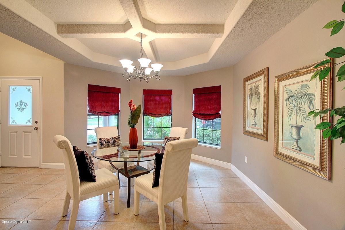 1202 Becket Place Melbourne, FL 32940 - Photo 5 of 38 a view of a dining room with furniture a chandelier and large windows