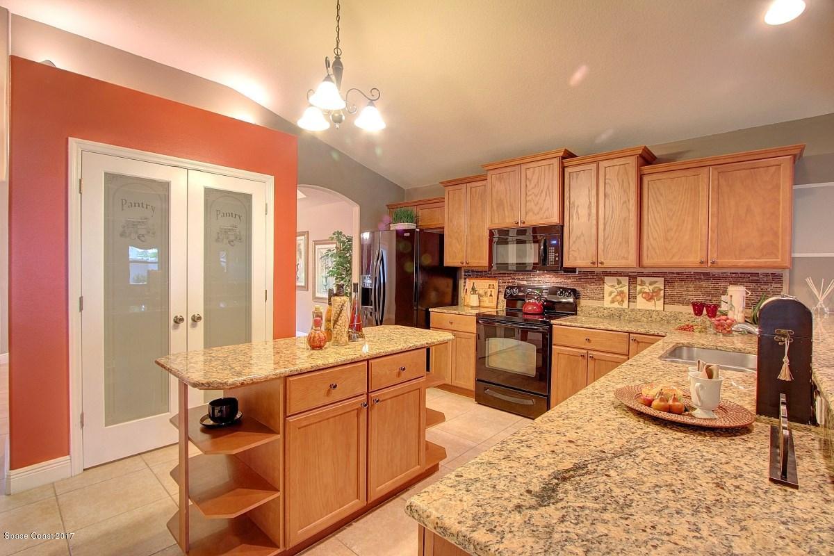 1202 Becket Place Melbourne, FL 32940 - Photo 7 of 38 a large kitchen with kitchen island a large counter space appliances and cabinets