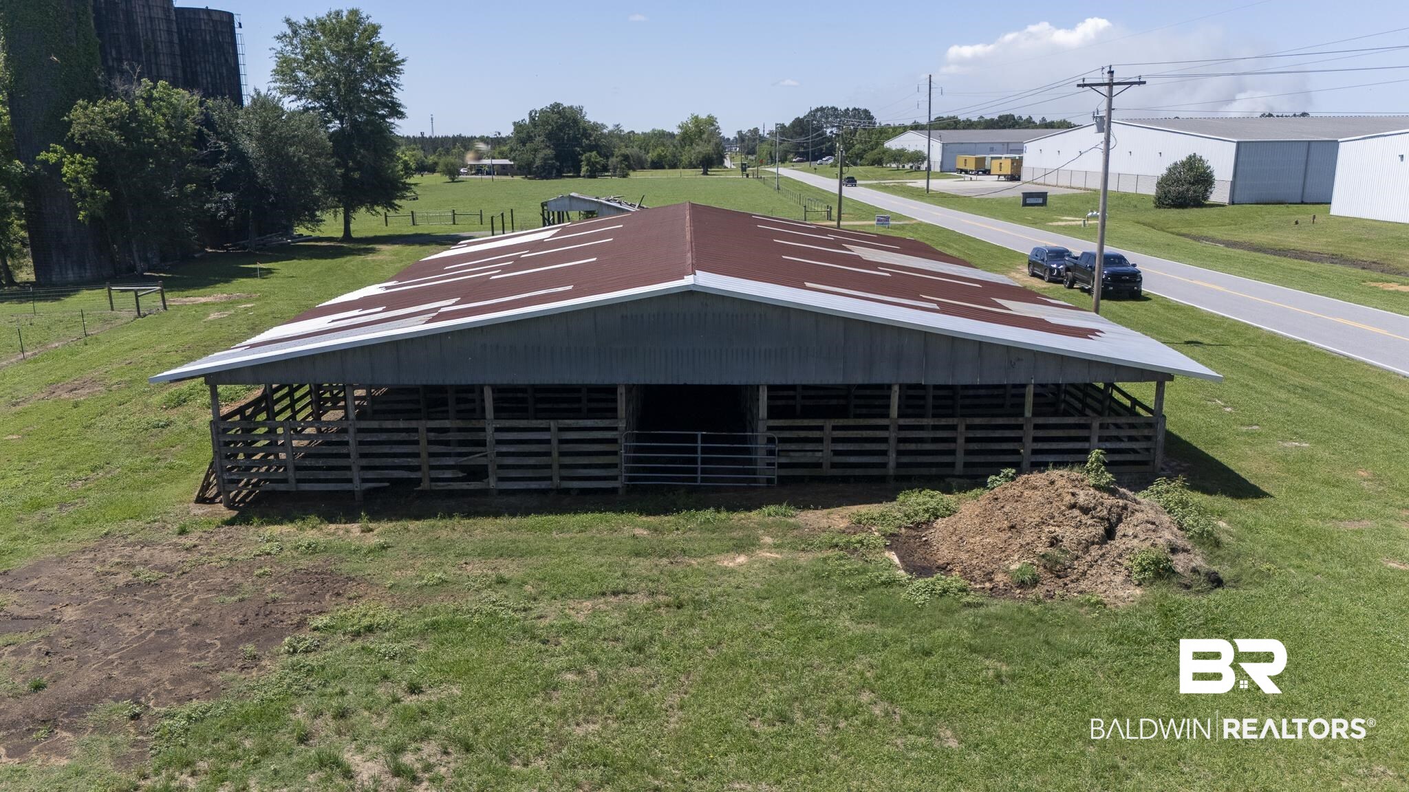 30580 County Road 49 Loxley, AL 36551 - Photo 30 of 32 Large agricultural structure featuring a corrugated metal roof and enclosed wooden pens