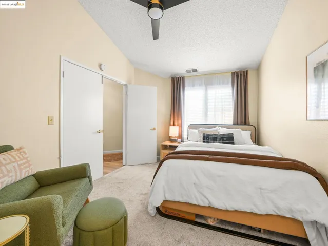 a bedroom with a bed couch and a window