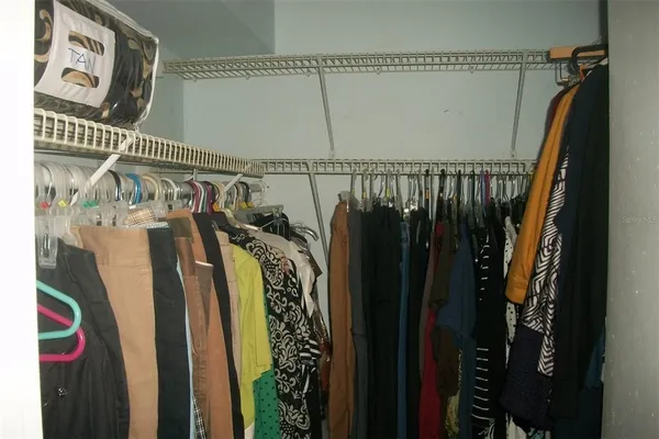 a view of walk in closet with clothes and shoes