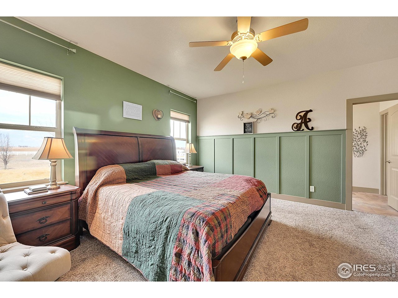 40775 Jade Drive Ault, CO 80610 - Photo 16 of 40 a bedroom with a bed and a chandelier