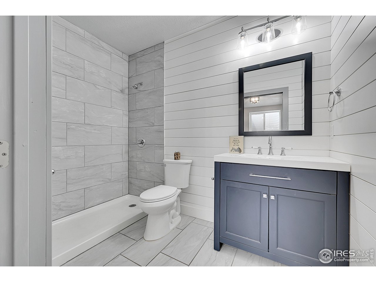 40775 Jade Drive Ault, CO 80610 - Photo 29 of 40 a bathroom with a sink a toilet a shower and a mirror