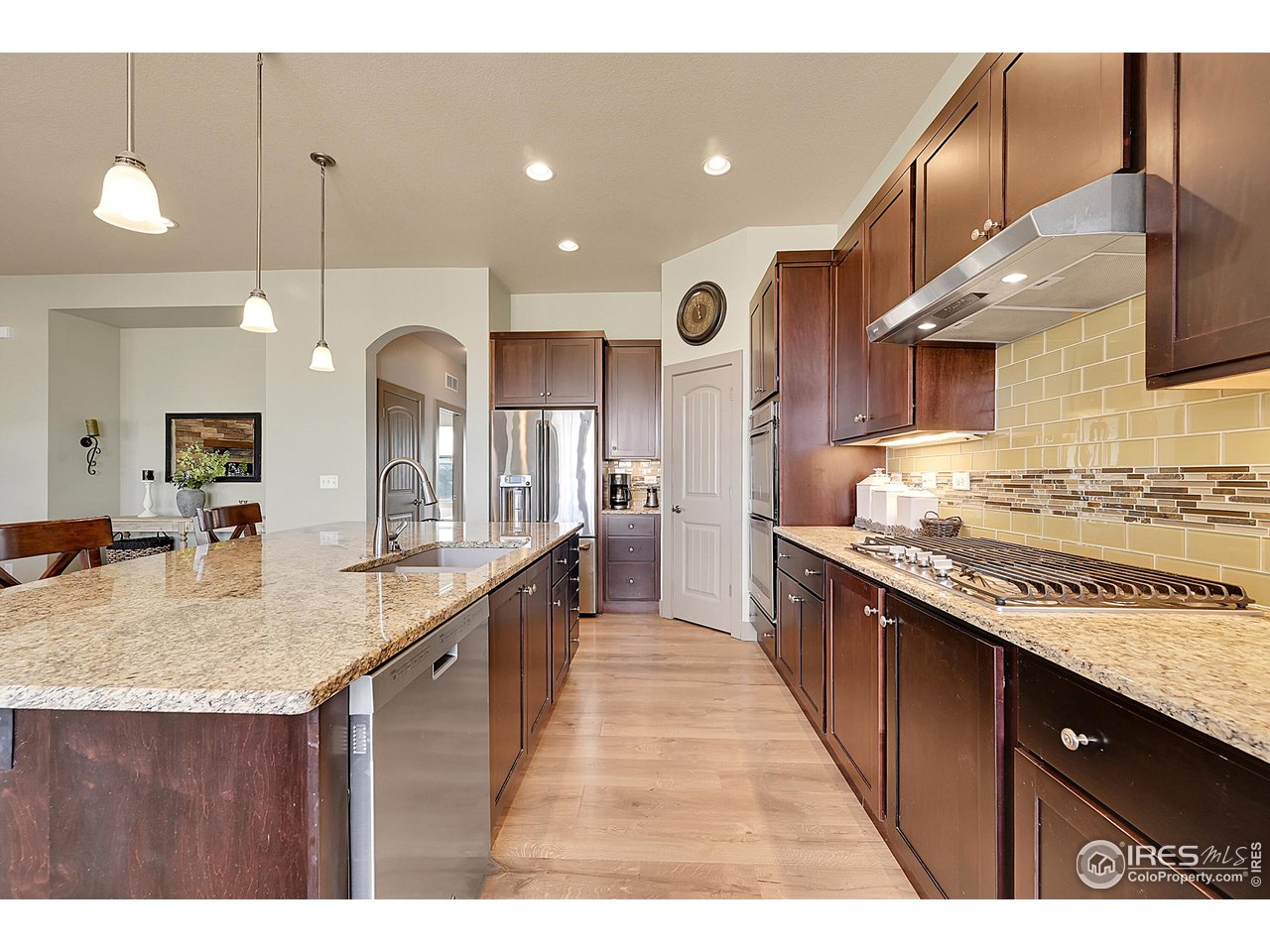 40775 Jade Drive Ault, CO 80610 - Photo 10 of 40 a kitchen with stainless steel appliances granite countertop a sink a stove and a wooden cabinets