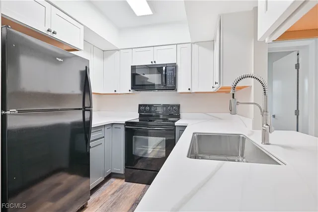 a kitchen with white cabinets and stainless steel appliances